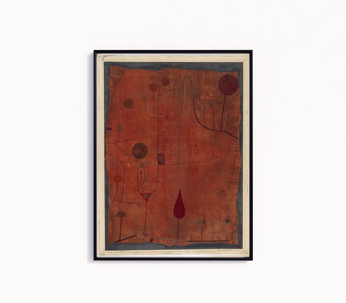 Framed art print of Fruits on Red (Früchte auf Rot) by Paul Klee, in a slim black frame on a plain white wall