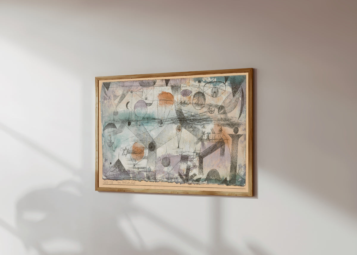 Framed art print of In the Realm of Air (Im Reich der Luft) by Paul Klee, in a light wood frame on a sunlit white wall, seen at a slight angle