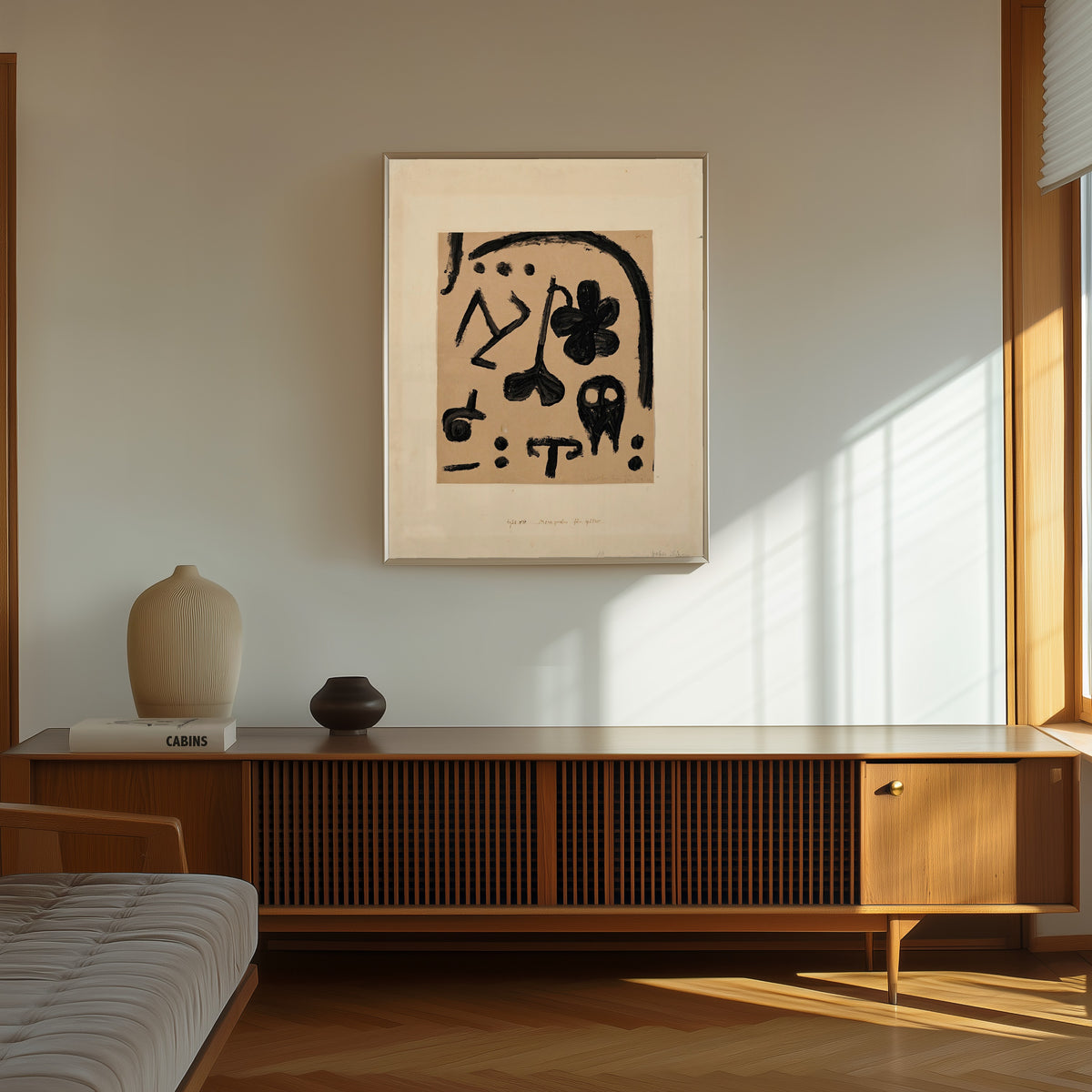 Framed art print of Marks for Later by Paul Klee, in a thin light frame on a sunlit wall above a wooden sideboard