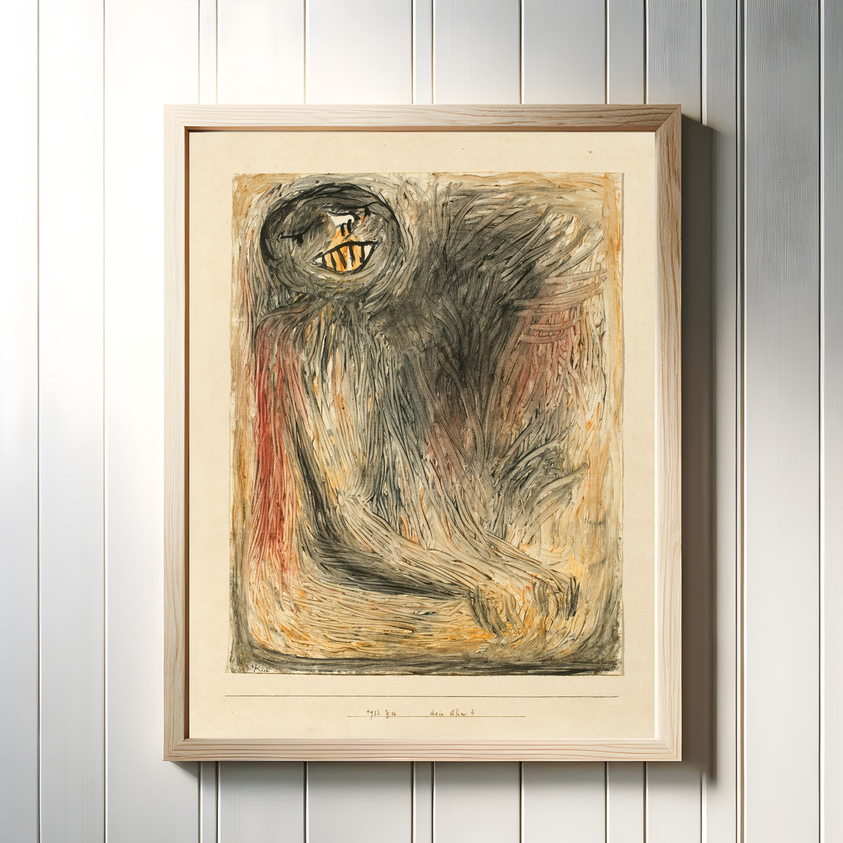 Framed art print of Your Ancestor (Dein Ahn) by Paul Klee, in a light wood frame on a white panelled wall