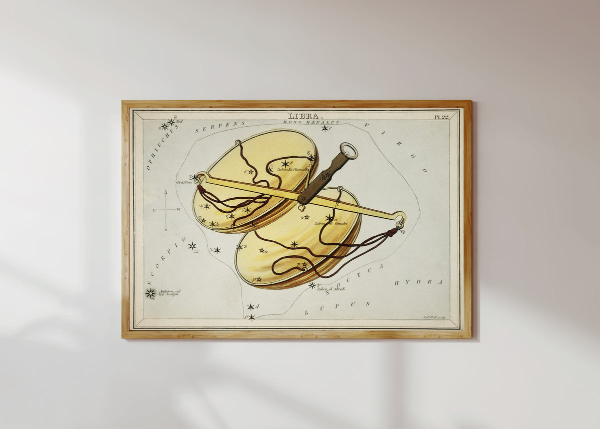 Framed art print of Libra by Sidney Hall, in a light wood frame on a sunlit white wall