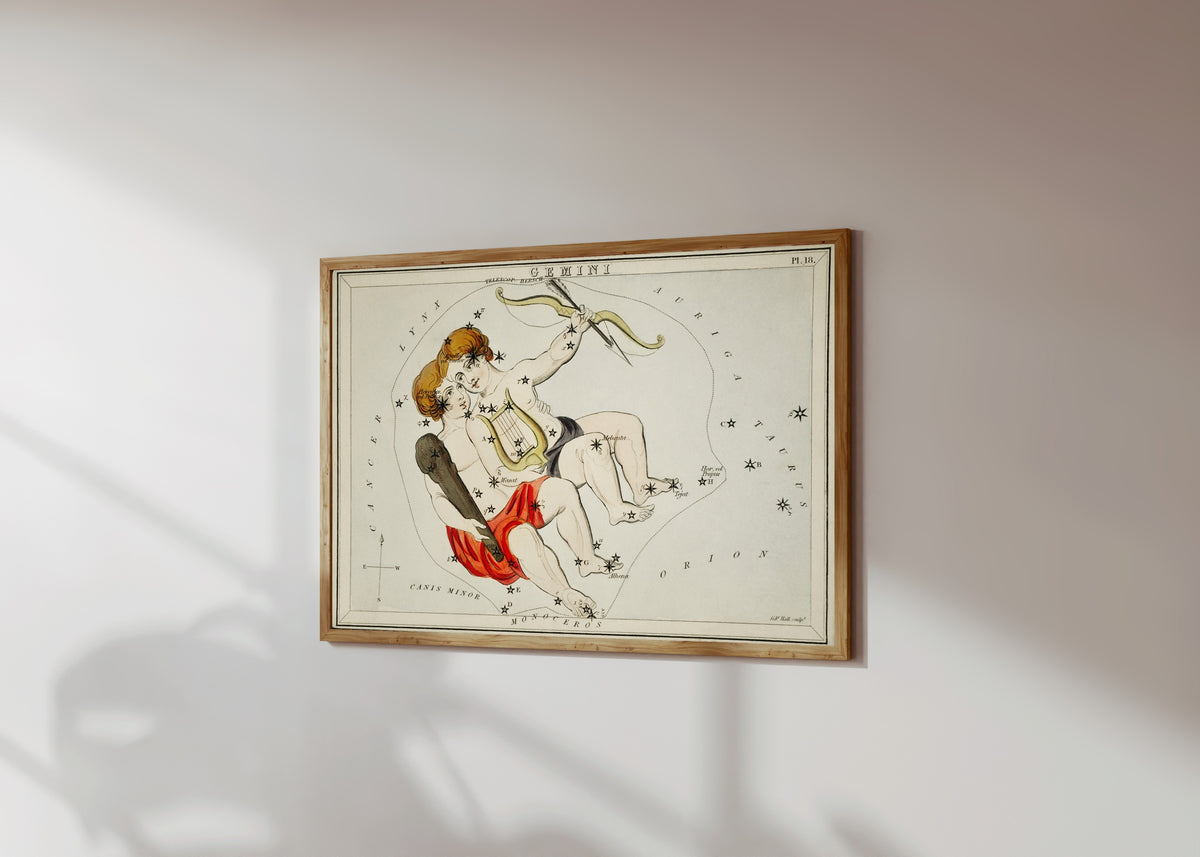 Framed art print of Gemini by Sidney Hall, in a light wood frame on a sunlit white wall, seen at a slight angle