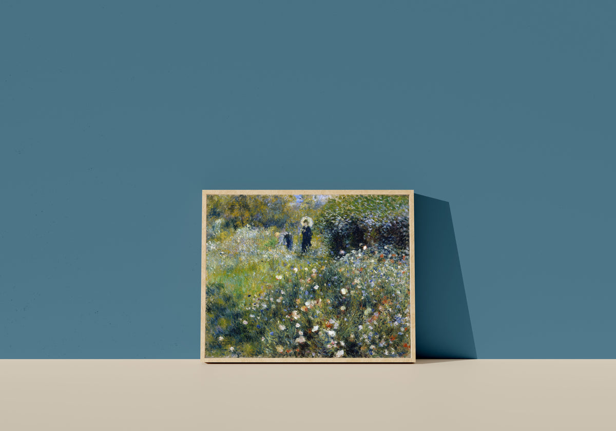 Framed art print of Woman with a Parasol in a Garden by Pierre-Auguste Renoir, in a light wood frame leaning on a blue wall