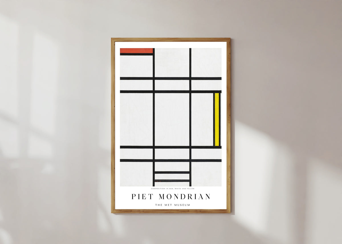 Framed art print of Composition by Piet Mondrian, in a light wood frame on a sunlit white wall