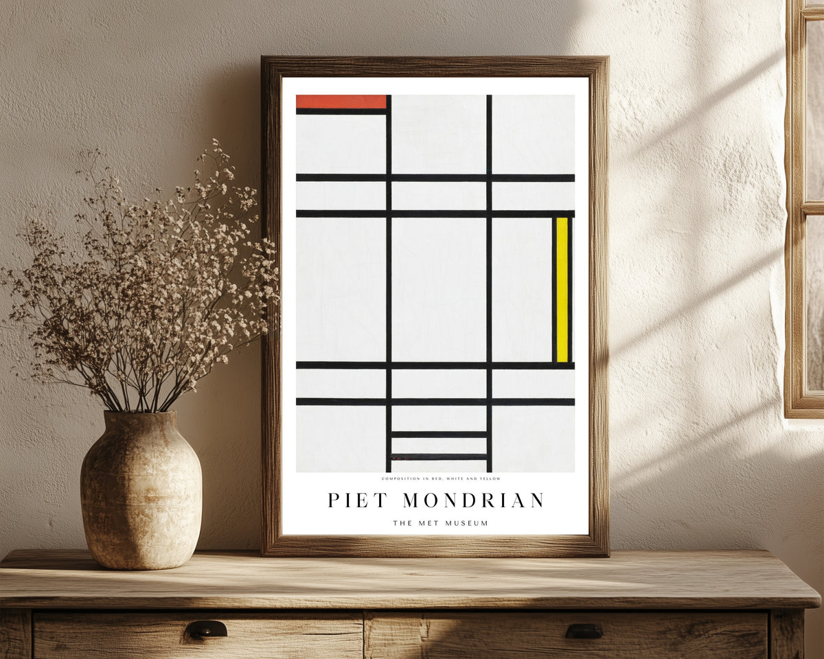 Framed art print of Composition by Piet Mondrian, in a dark wood frame leaning on a rustic console beside dried flowers