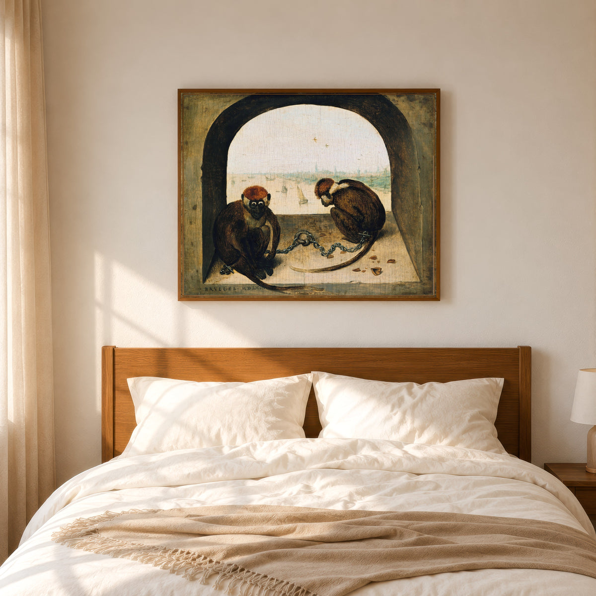 Framed art print of Two Chained Monkeys by Pieter Bruegel the Elder, in a slim wood frame above a bed in a sunlit bedroom