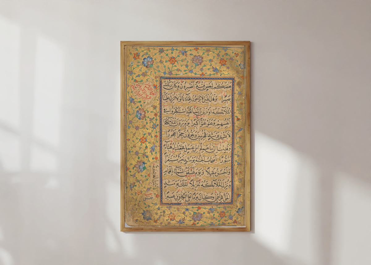Framed art print of Quran Folio by Ibrahim Sultan (Timurid), in a light wood frame on a sunlit white wall