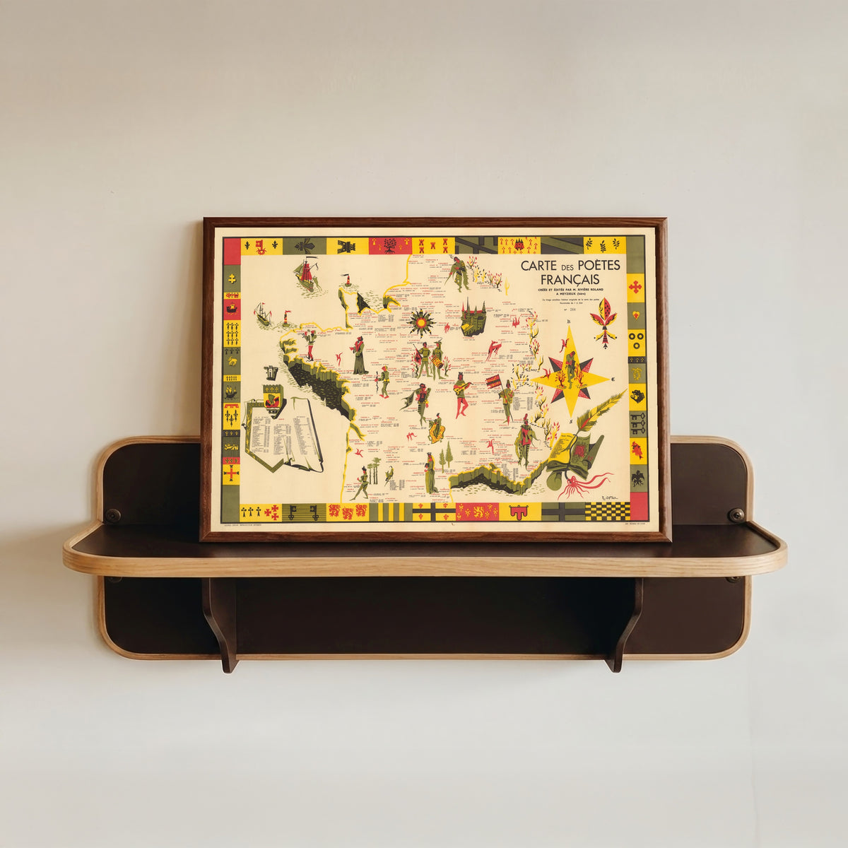 Framed art print of Carte des Poètes Français by R. Gattaz, in a dark wood frame resting on a wall shelf