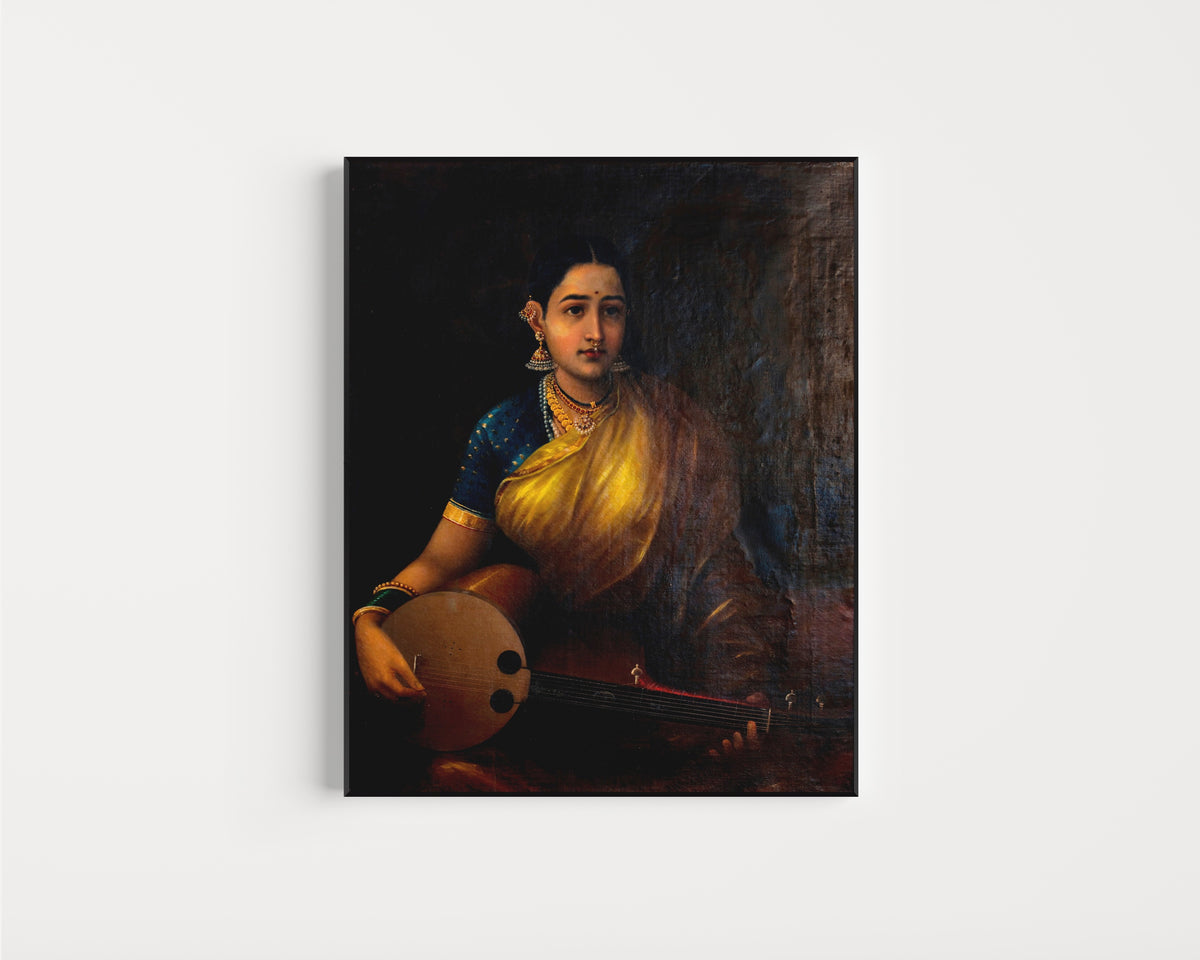 Framed art print of A Tamil Lady Playing the Swarbat by Raja Ravi Varma, in a slim black frame on a plain white wall