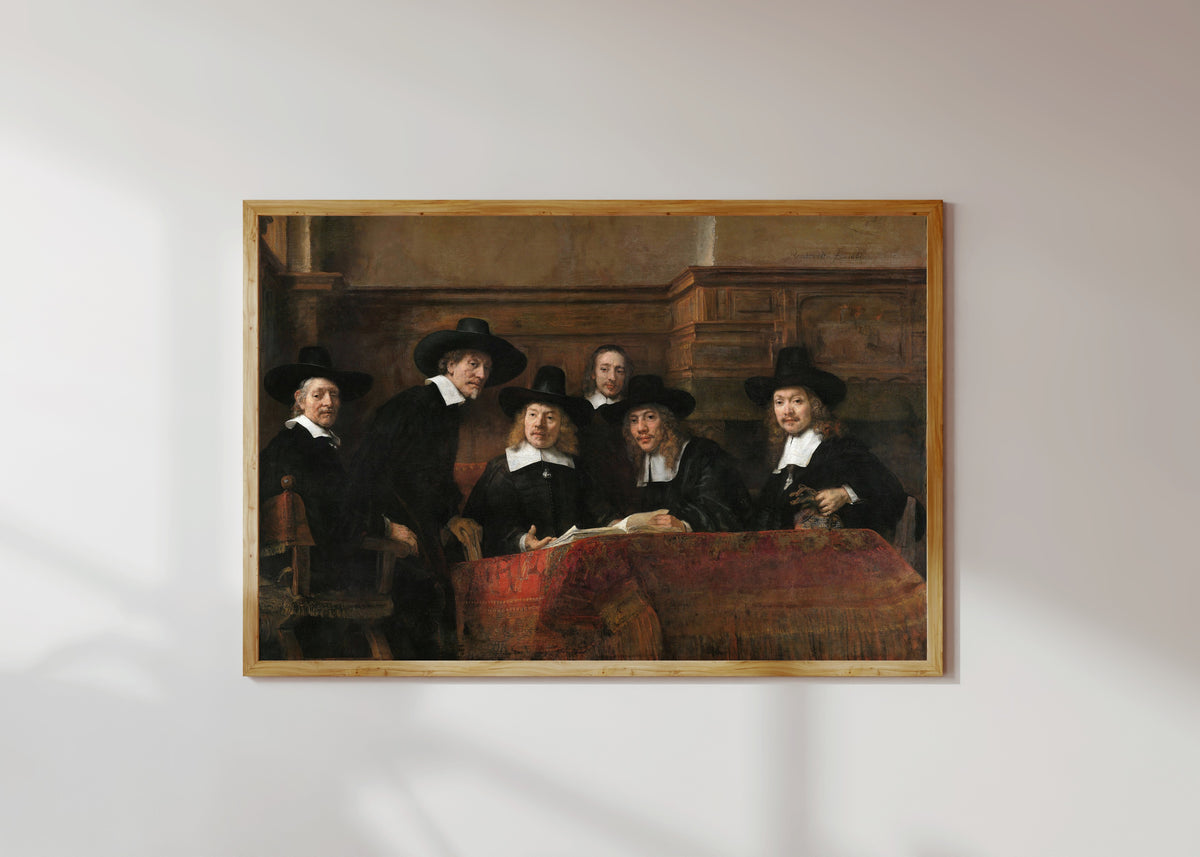 Framed art print of The Sampling Officials of the Amsterdam Drapers' Guild, Known as 'The… by Rembrandt van Rijn, in a light wood frame on a sunlit white wall