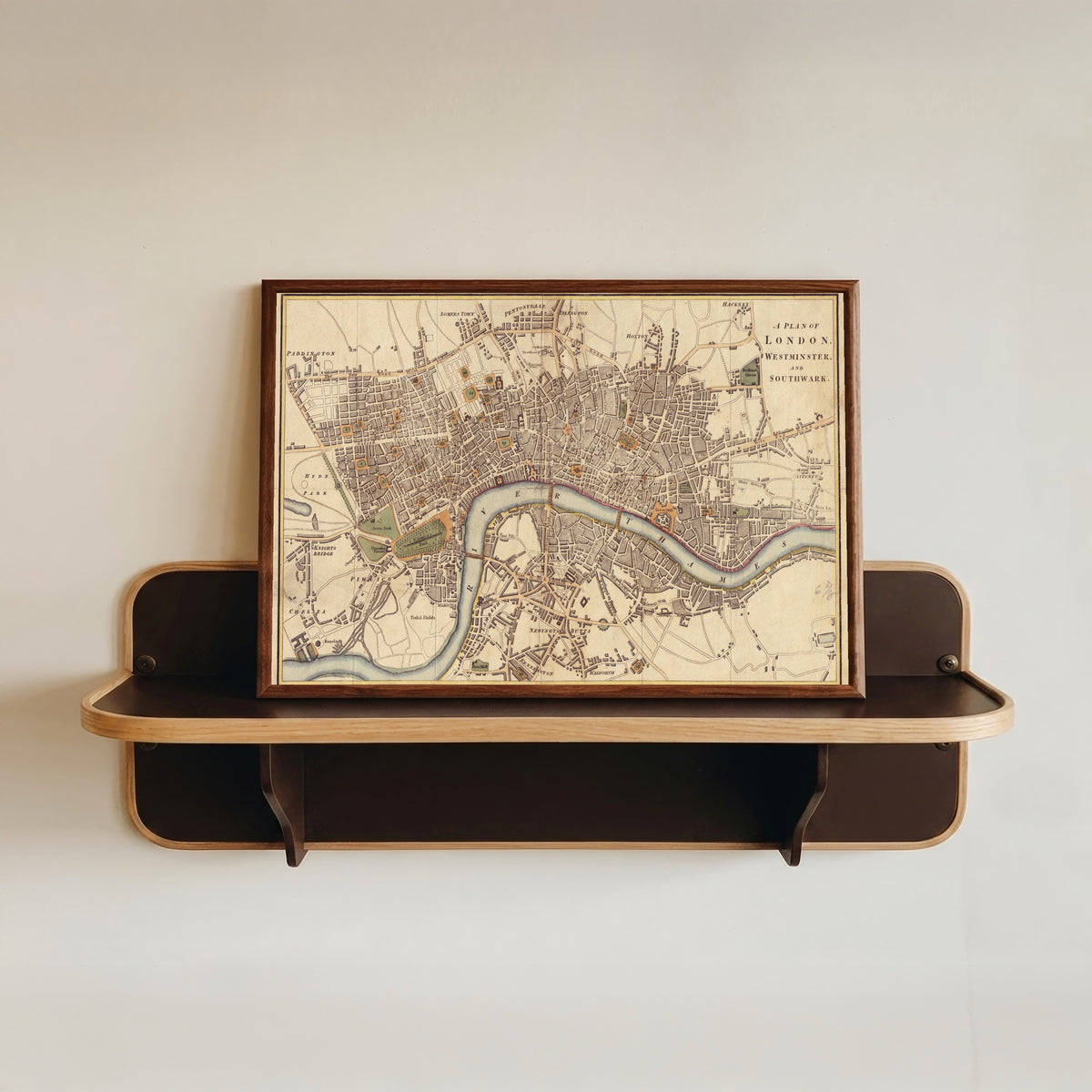 Framed art print of A Plan of London, Westminster and Southwark by Richard Phillips, in a dark wood frame resting on a wall shelf