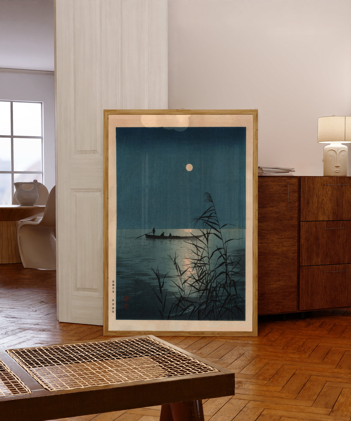 Framed art print of Moonlit Sea by Shoda Koho, in a light wood frame leaning in a warm room with a parquet floor