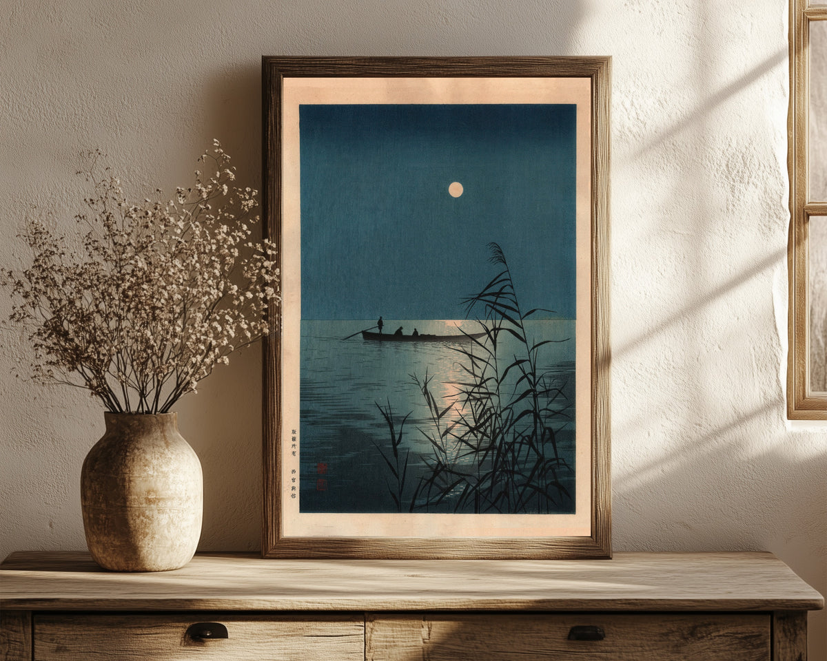 Framed art print of Moonlit Sea by Shoda Koho, in a dark wood frame leaning on a rustic console beside dried flowers
