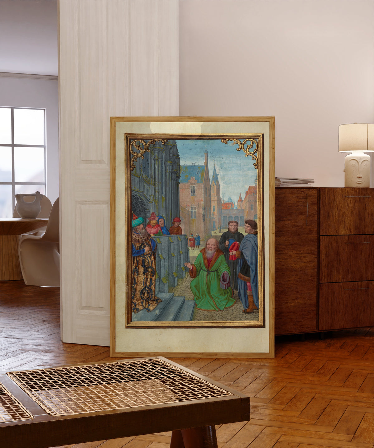 Framed art print of Joseph of Arimathea Before Pilate by Simon Bening, in a light wood frame leaning in a warm room with a parquet floor
