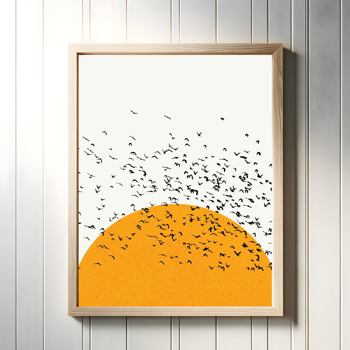 Framed art print of Sunset and Birds by Bauhaus, in a light wood frame on a white panelled wall