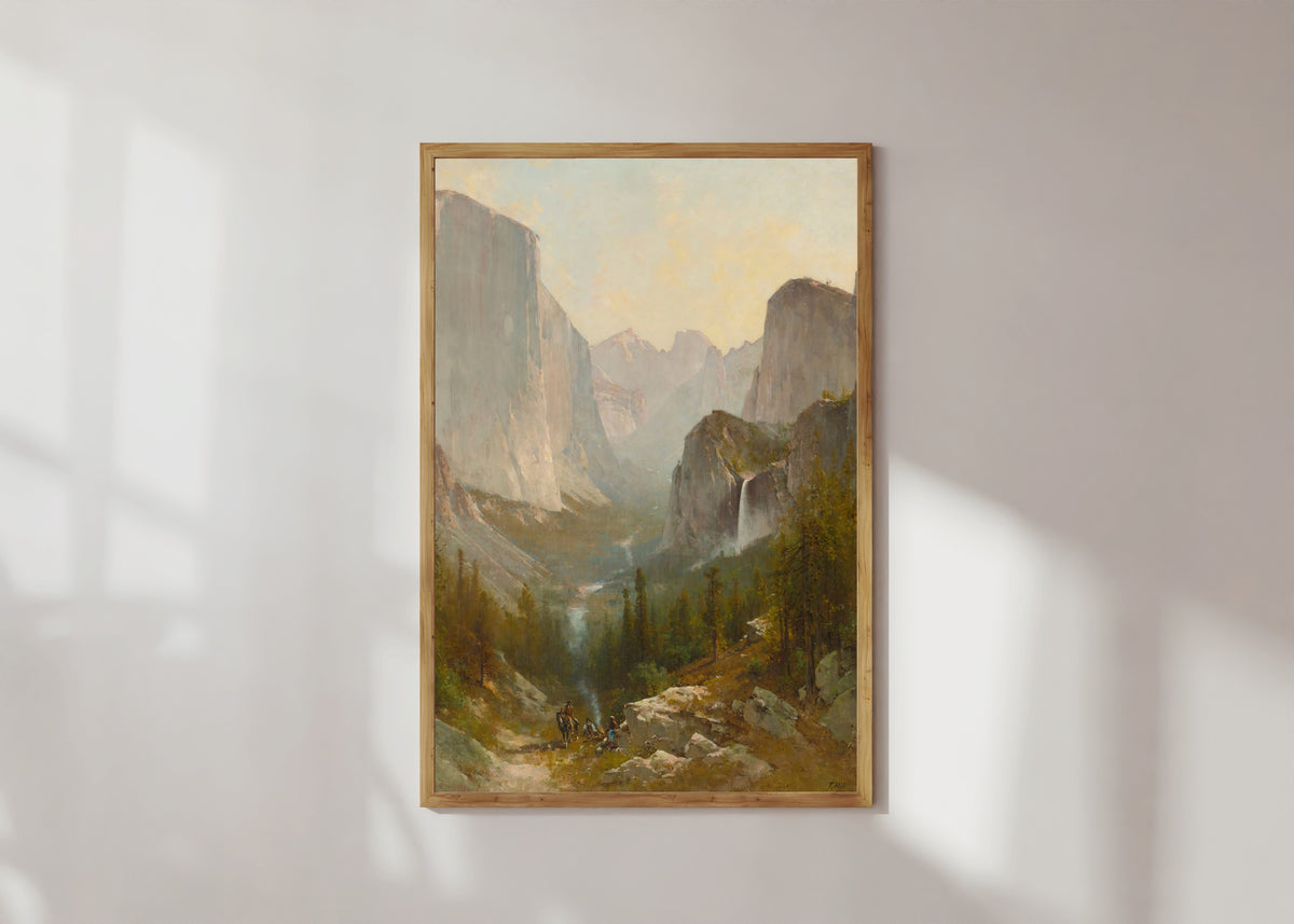 Framed art print of Yosemite Valley by Thomas Hill, in a light wood frame on a sunlit white wall