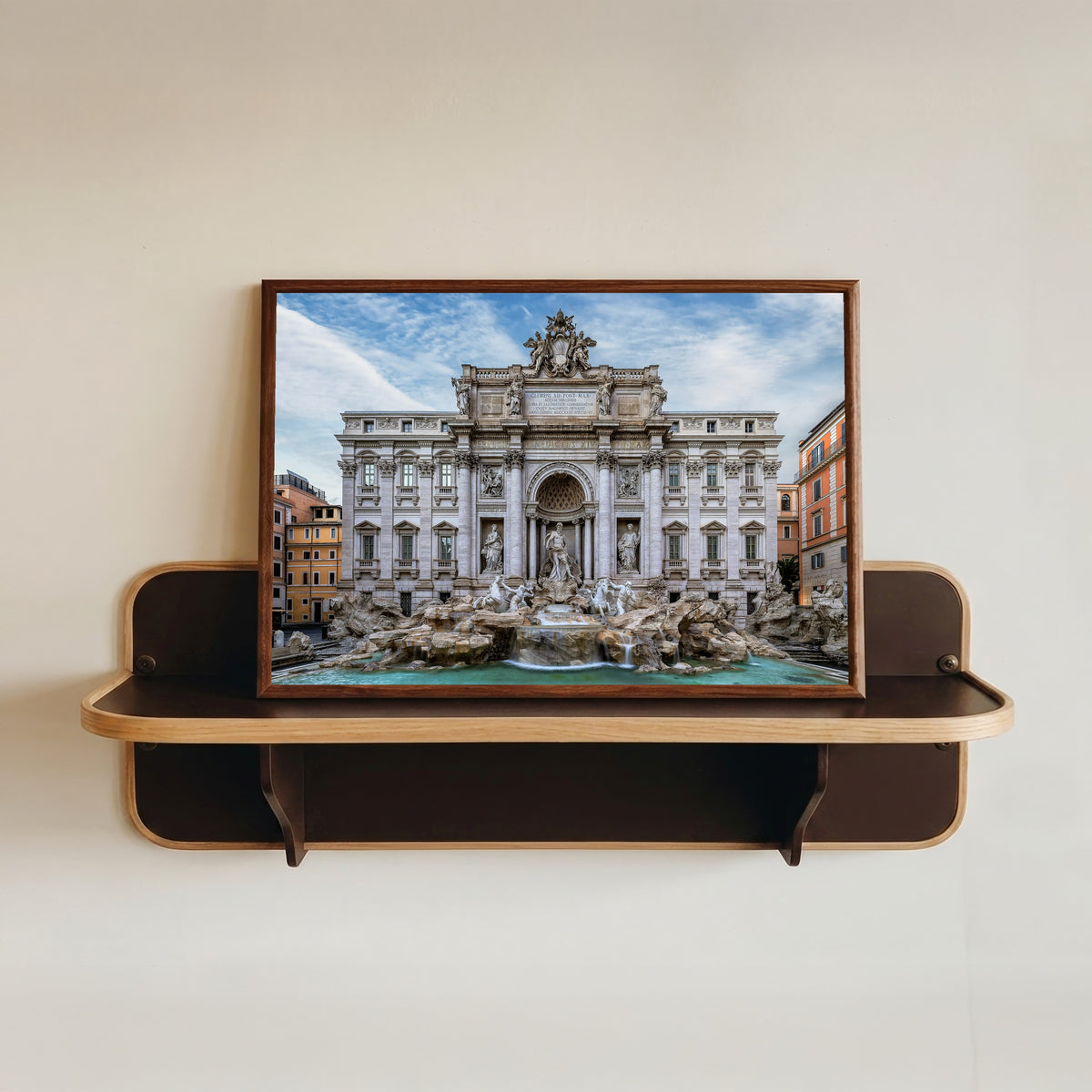 Framed art print of Trevi Fountain (Rome) by Pablo Meilán Campagnale, in a dark wood frame resting on a wall shelf