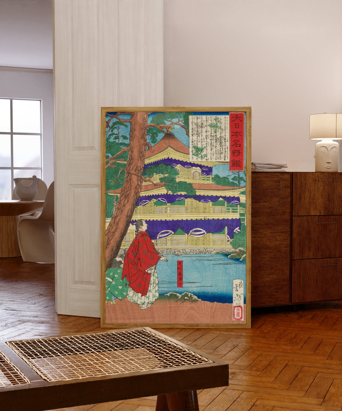 Framed art print of Ashikaga Yoshimitsu Admiring the Golden Pavilion by Tsukioka Yoshitoshi, in a light wood frame leaning in a warm room with a parquet floor
