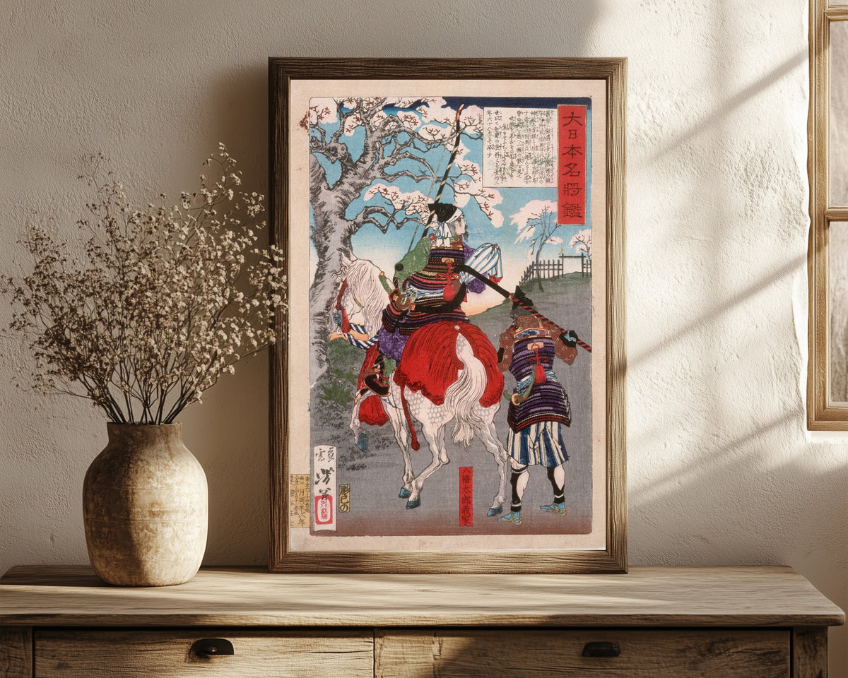Framed art print of Hachimantarō Yoshiie at Nakoso Barrier by Tsukioka Yoshitoshi, in a dark wood frame leaning on a rustic console beside dried flowers