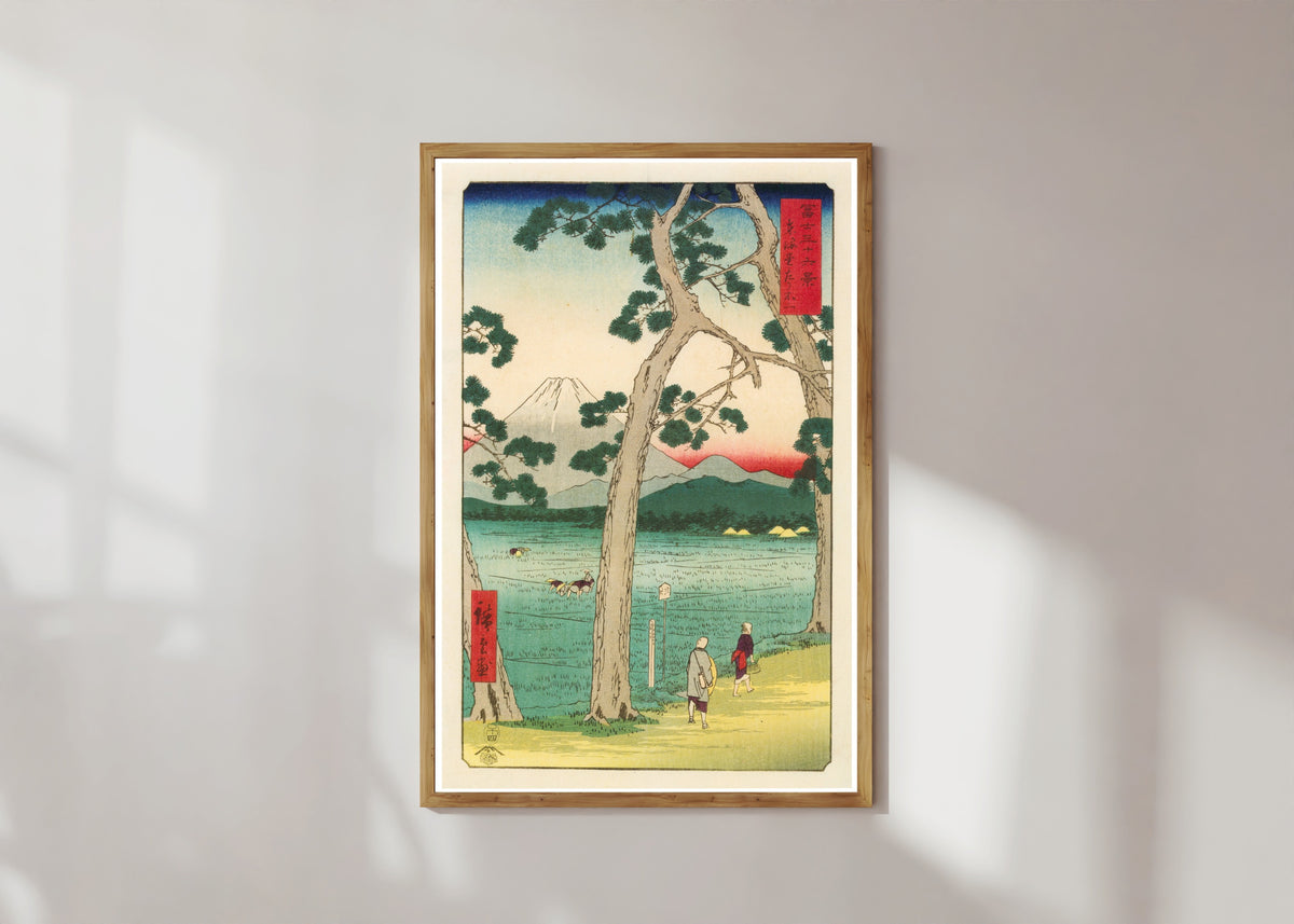 Framed art print of Fuji on the left of the Tōkaidō Road by Utagawa Hiroshige, in a light wood frame on a sunlit white wall