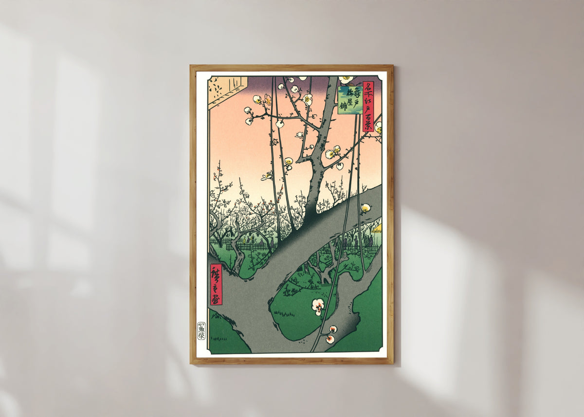 Framed art print of Plum Park in Kameido by Utagawa Hiroshige, in a light wood frame on a sunlit white wall