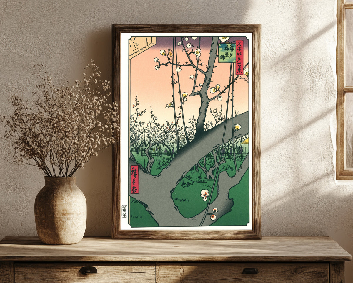 Framed art print of Plum Park in Kameido by Utagawa Hiroshige, in a dark wood frame leaning on a rustic console beside dried flowers
