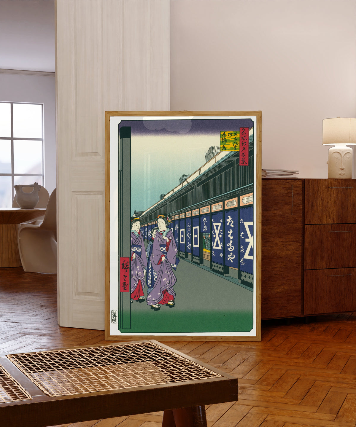 Framed art print of Shops with Cotton Goods in Ōdenma-chō by Utagawa Hiroshige, in a light wood frame leaning in a warm room with a parquet floor