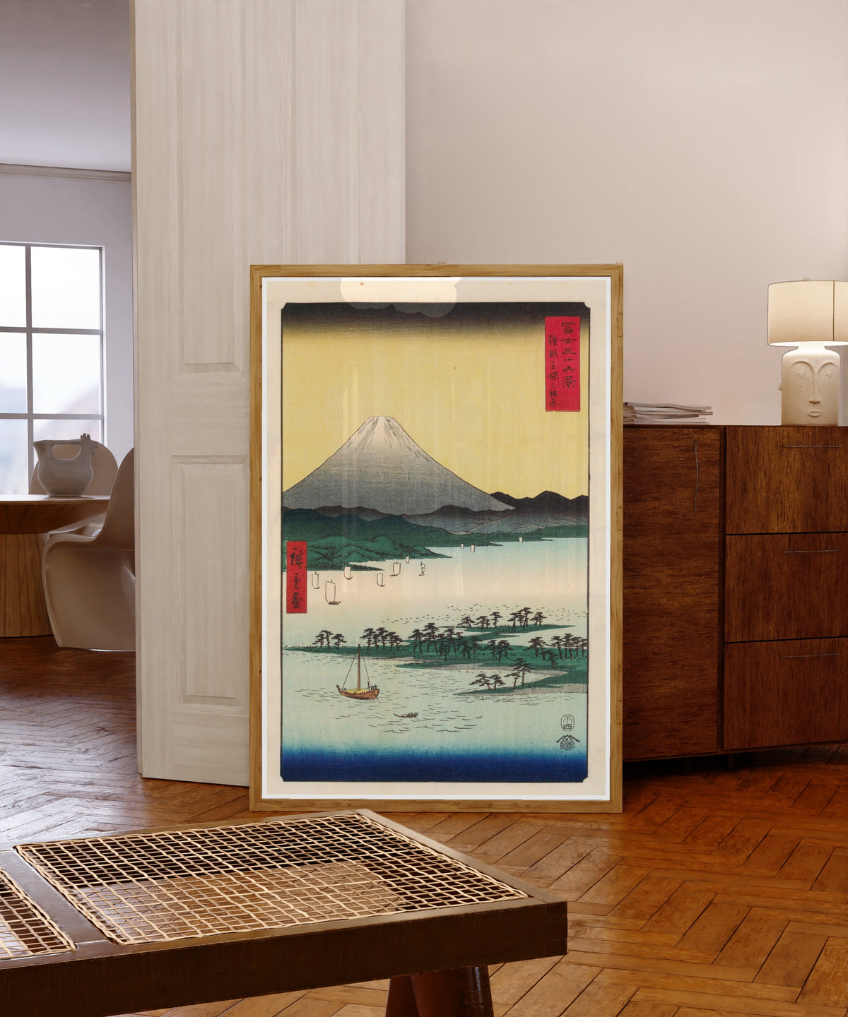 Framed art print of The Pine Forest of Miho in Suruga Province by Utagawa Hiroshige, in a light wood frame leaning in a warm room with a parquet floor