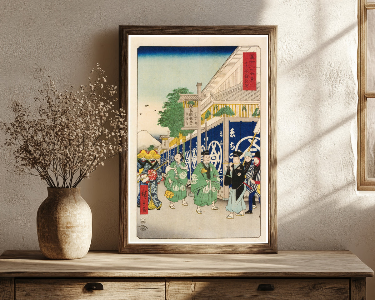 Framed art print of Thirty-six Views of Mount Fuji: The Suruga… by Utagawa Hiroshige, in a dark wood frame leaning on a rustic console beside dried flowers