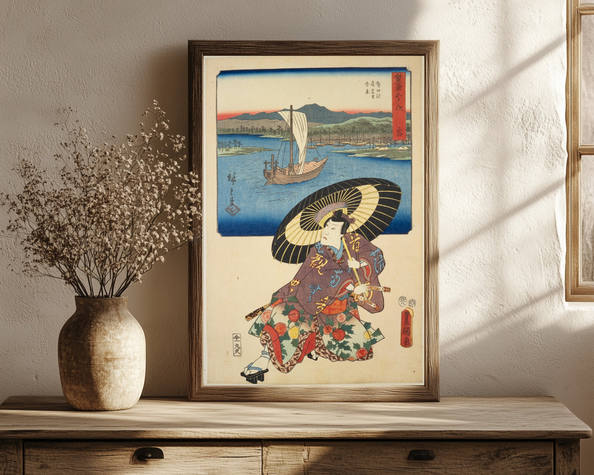 Framed art print of Fifty-three Stations by Two… by Utagawa Hiroshige & Utagawa Kunisada, in a dark wood frame leaning on a rustic console beside dried flowers
