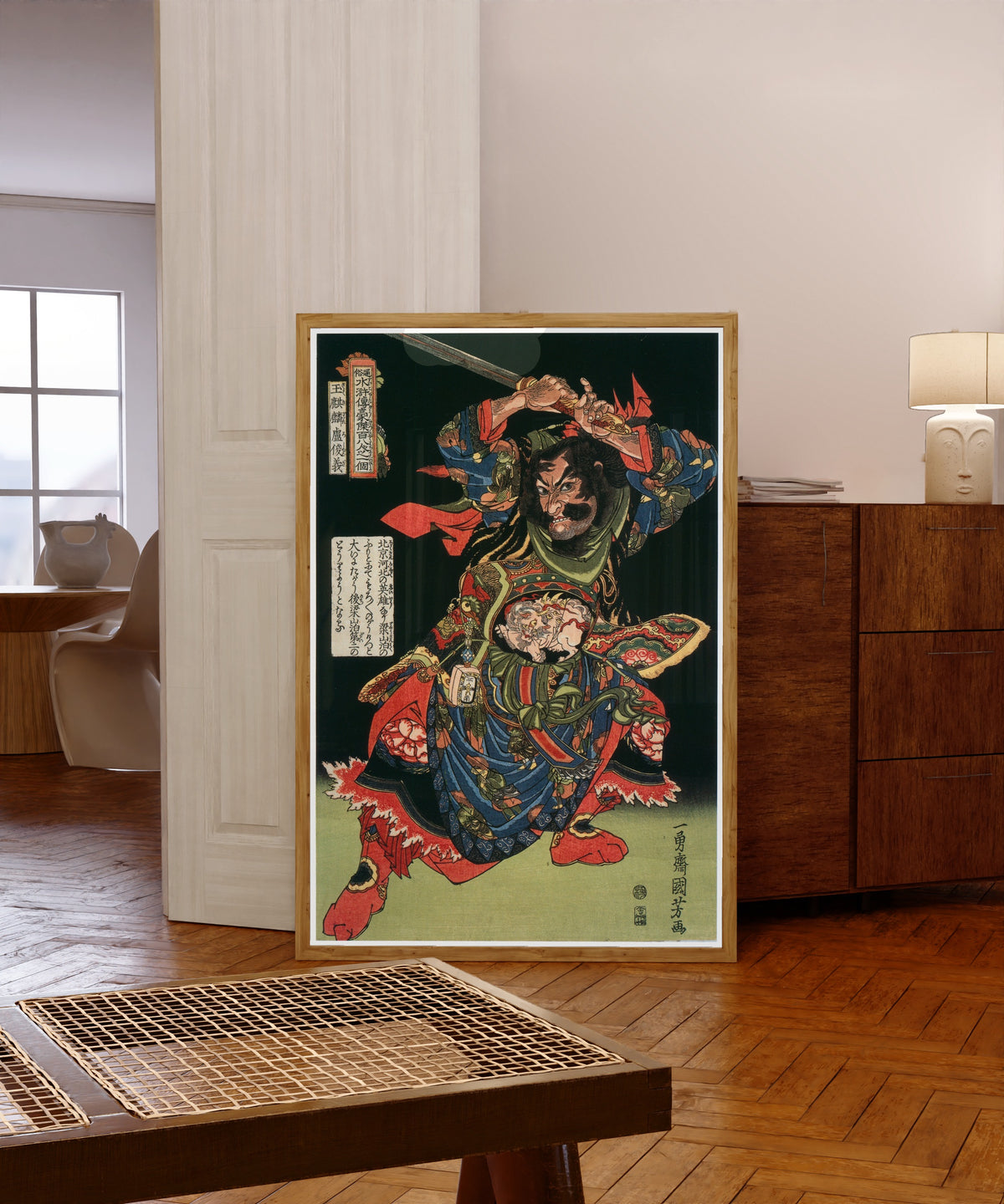 Framed art print of 108 Heroes of the Suikoden: Gyokkirin Roshungi… by Utagawa Kuniyoshi, in a light wood frame leaning in a warm room with a parquet floor