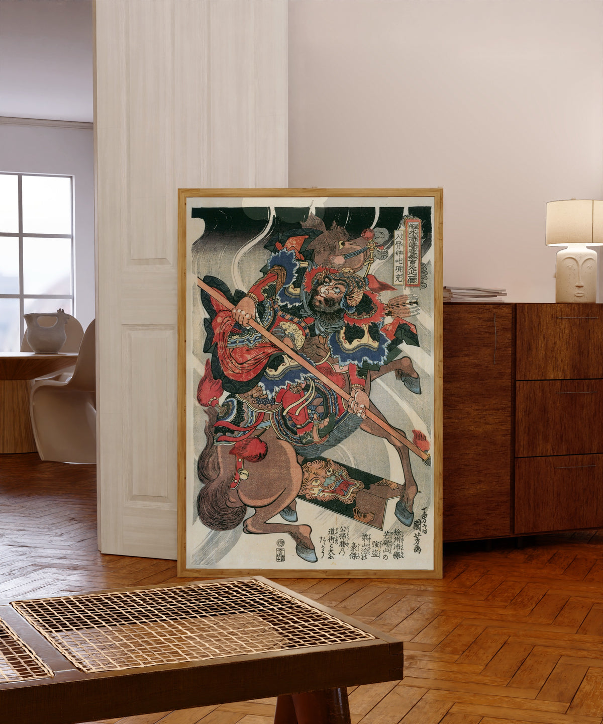 Framed art print of 108 Heroes of the Suikoden: Happi Nata Kōjū by Utagawa Kuniyoshi, in a light wood frame leaning in a warm room with a parquet floor