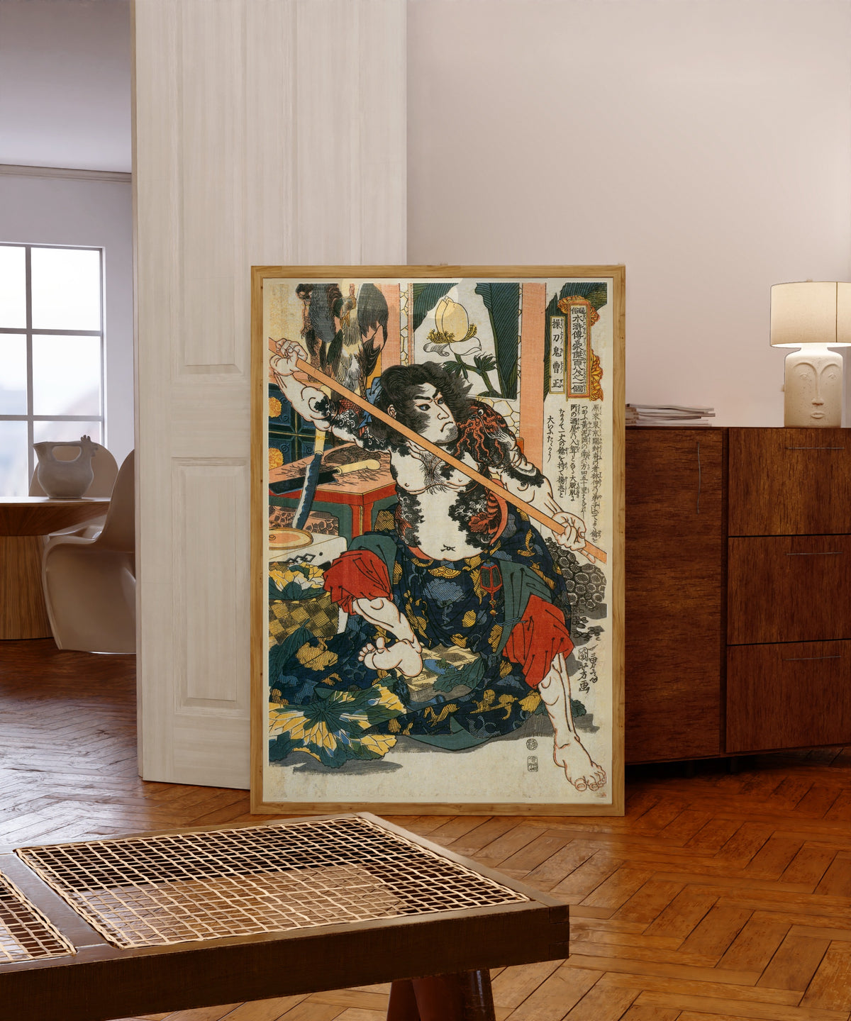 Framed art print of 108 Heroes of the Suikoden: Sōtōki Sōsei by Utagawa Kuniyoshi, in a light wood frame leaning in a warm room with a parquet floor