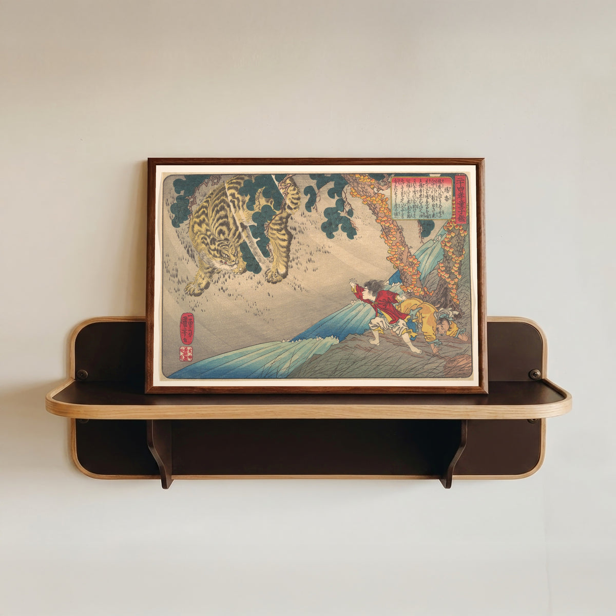 Framed art print of Yang Xiang (Yōkō) Protects Her Father from a Tiger, 24 Paragons of… by Utagawa Kuniyoshi, in a dark wood frame resting on a wall shelf