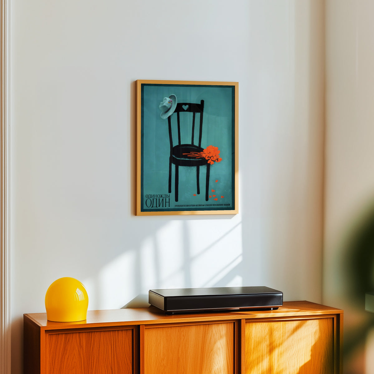 Framed art print of Once One by V. Strimaitis, in a light wood frame on a white wall above an orange sideboard