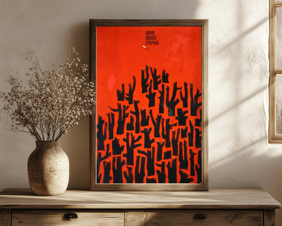 Framed art print of The Price of One Match by V. Strimaitis, in a dark wood frame leaning on a rustic console beside dried flowers