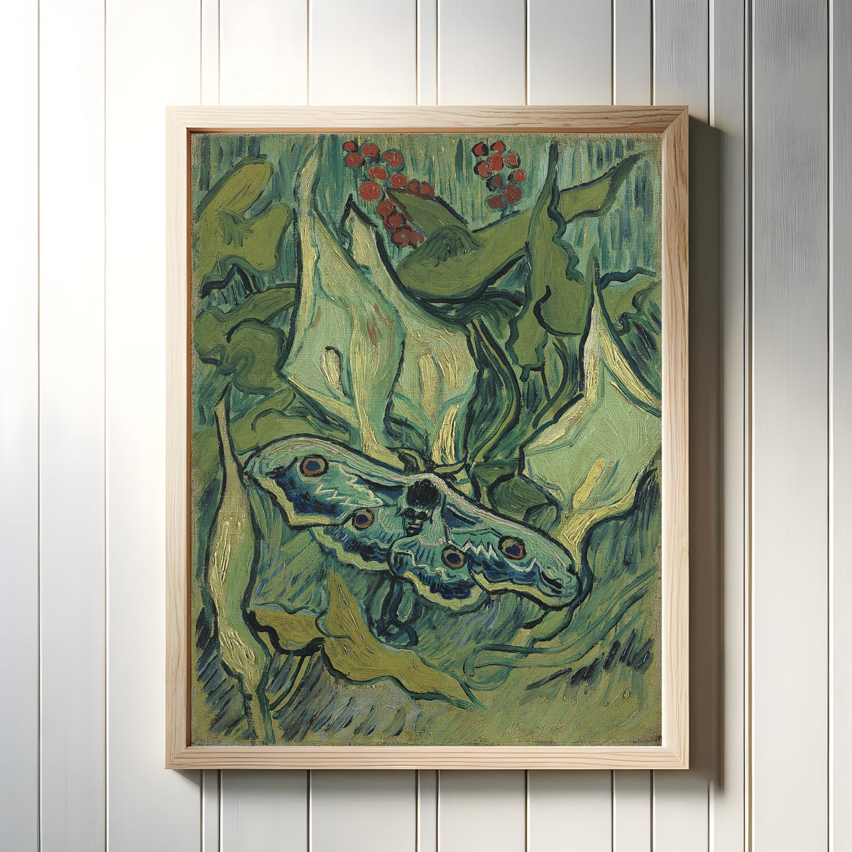 Framed art print of Giant Peacock Moth by Vincent van Gogh, in a light wood frame on a white panelled wall