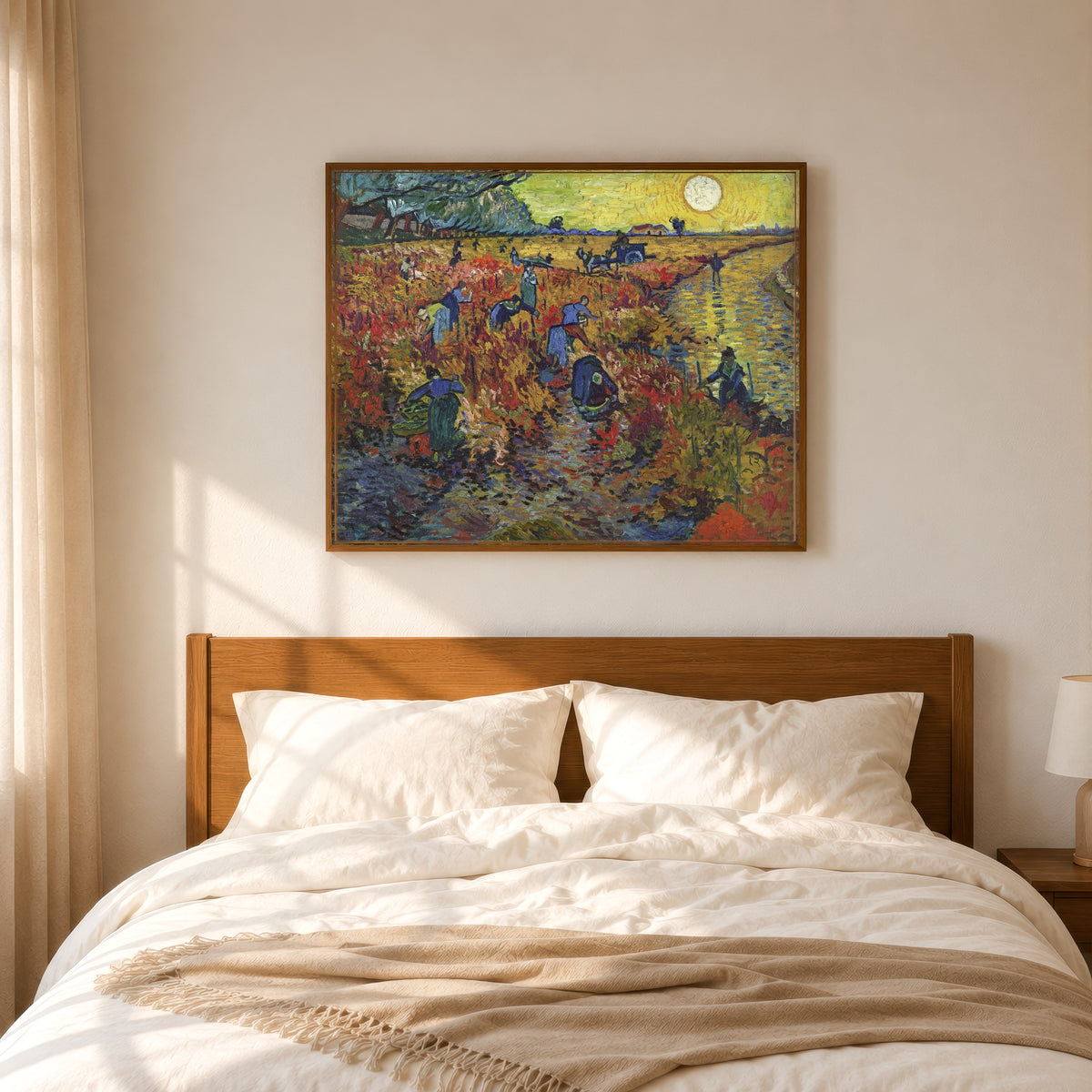 Framed art print of The Red Vineyard by Vincent van Gogh, in a slim wood frame above a bed in a sunlit bedroom