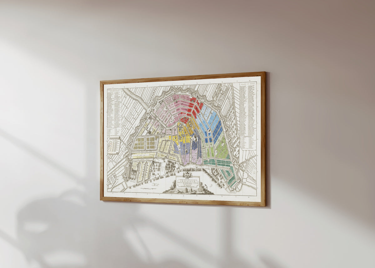 Framed art print of Nieuwe Platte Grond der Stad Amsteldam by Covens & Mortier, in a light wood frame on a sunlit white wall, seen at a slight angle
