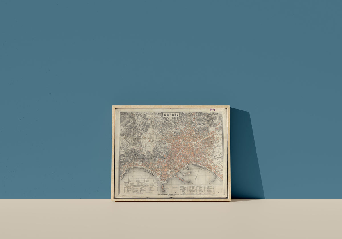Framed art print of Map of Naples, in a light wood frame leaning on a blue wall