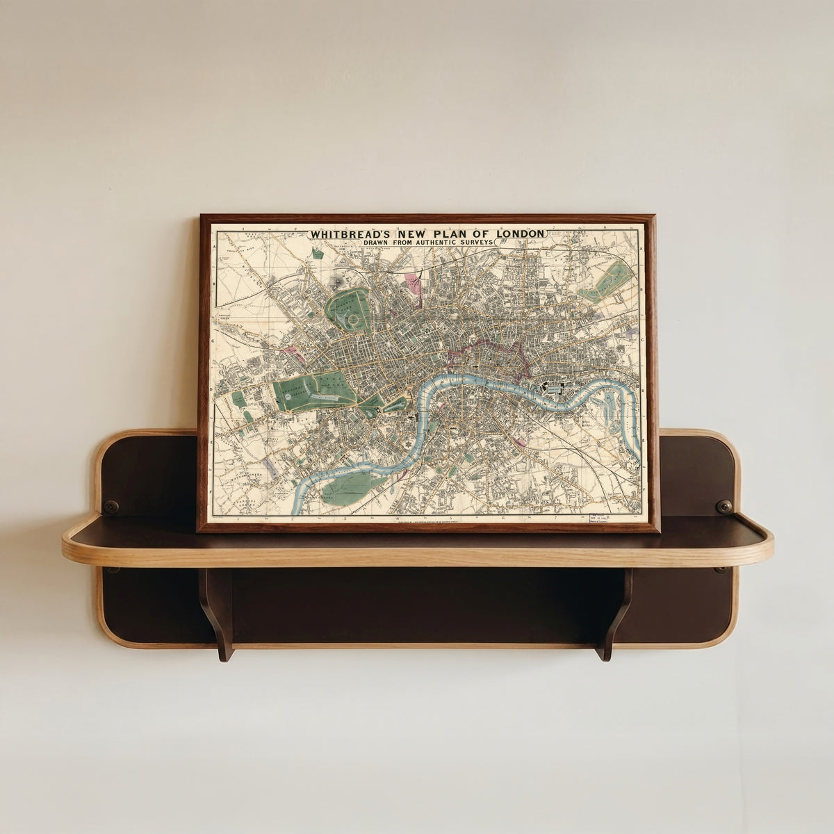 Framed art print of Whitbread's New Plan of London, in a dark wood frame resting on a wall shelf