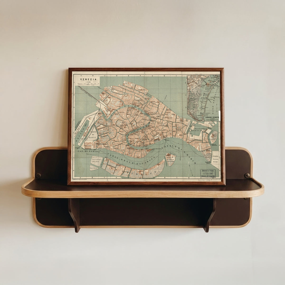 Framed art print of Venezia by Wagner & Debes, in a dark wood frame resting on a wall shelf