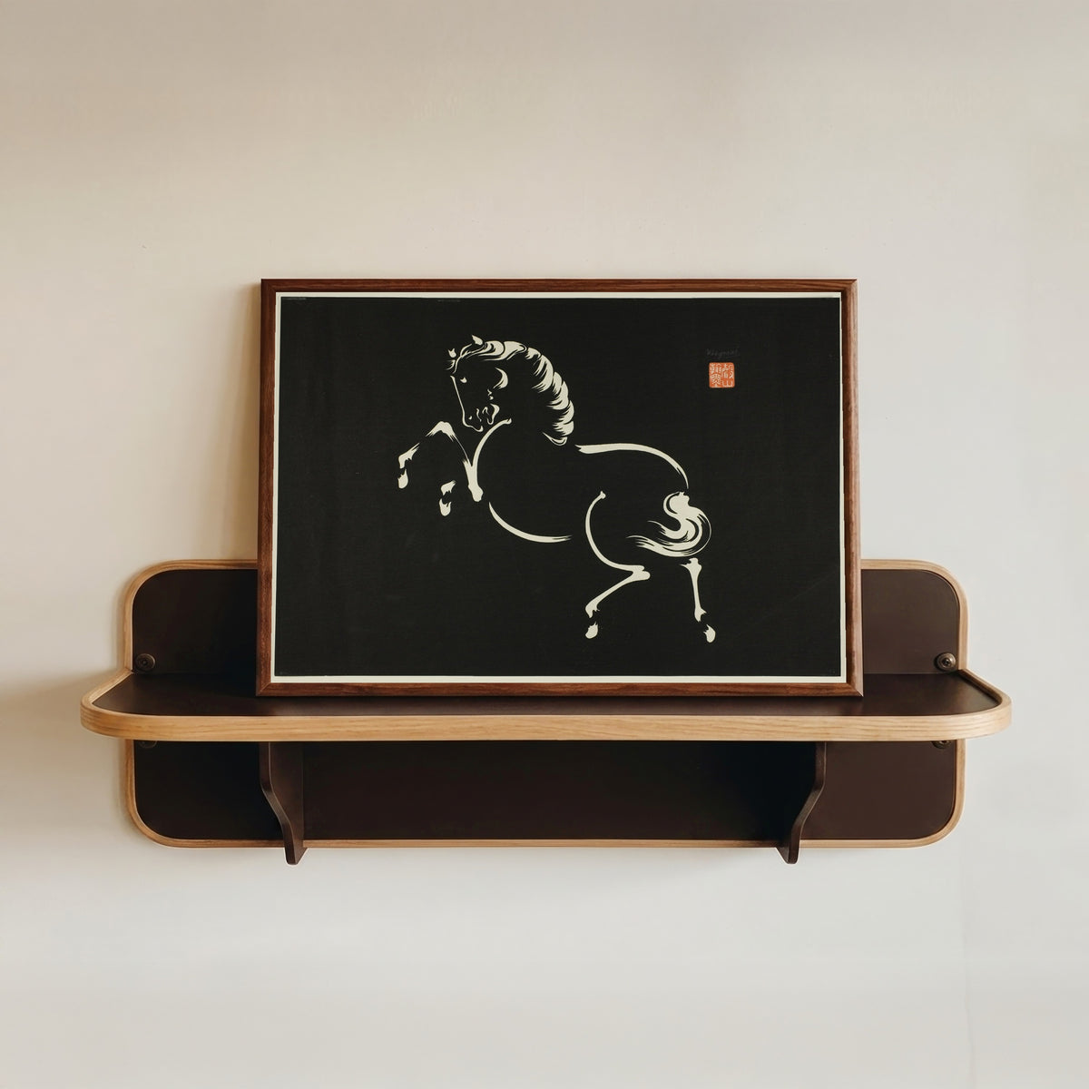Framed art print of Rearing Horse by Wakyosai, in a dark wood frame resting on a wall shelf