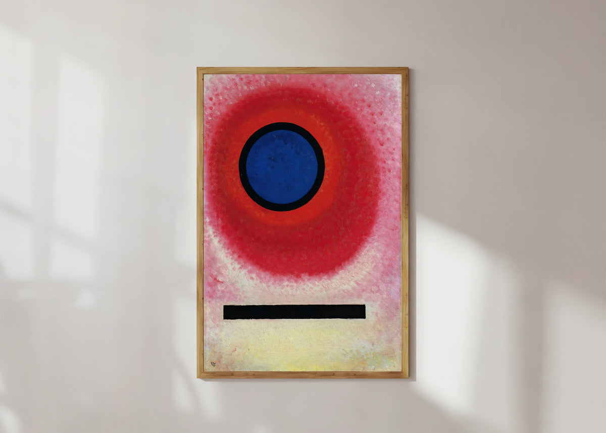 Framed art print of Blue Circle 2 by Wassily Kandinsky, in a light wood frame on a sunlit white wall