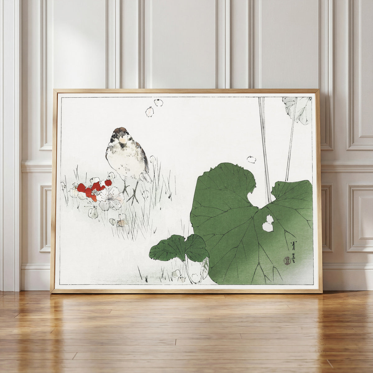 Framed art print of Eurasian tree sparrow by Watanabe Seitei, in a light wood frame leaning against a panelled white wall