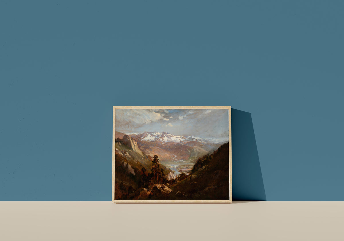 Framed art print of Snow in the Valley of Eastern Sierras by William Keith, in a light wood frame leaning on a blue wall