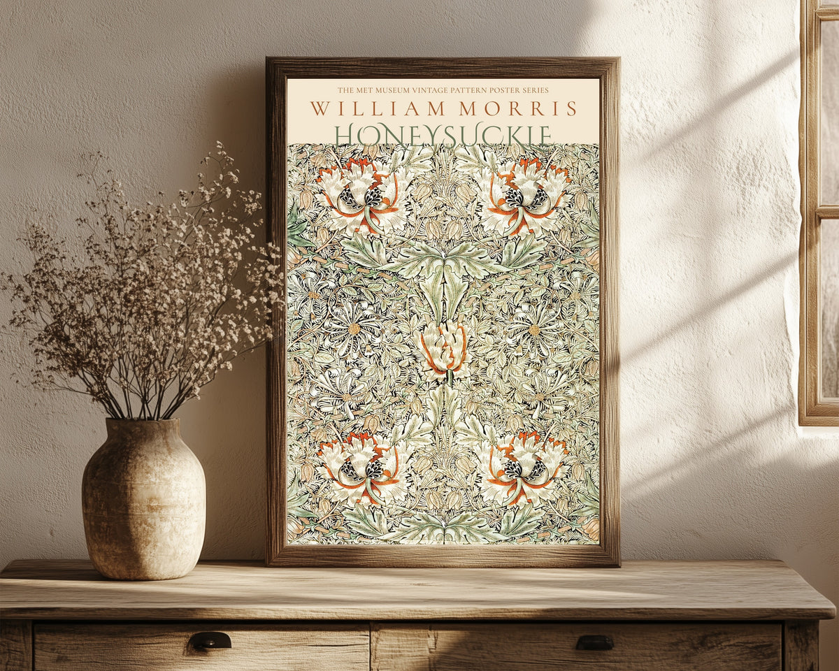 Framed art print of Honeysuckle by William Morris, in a dark wood frame leaning on a rustic console beside dried flowers