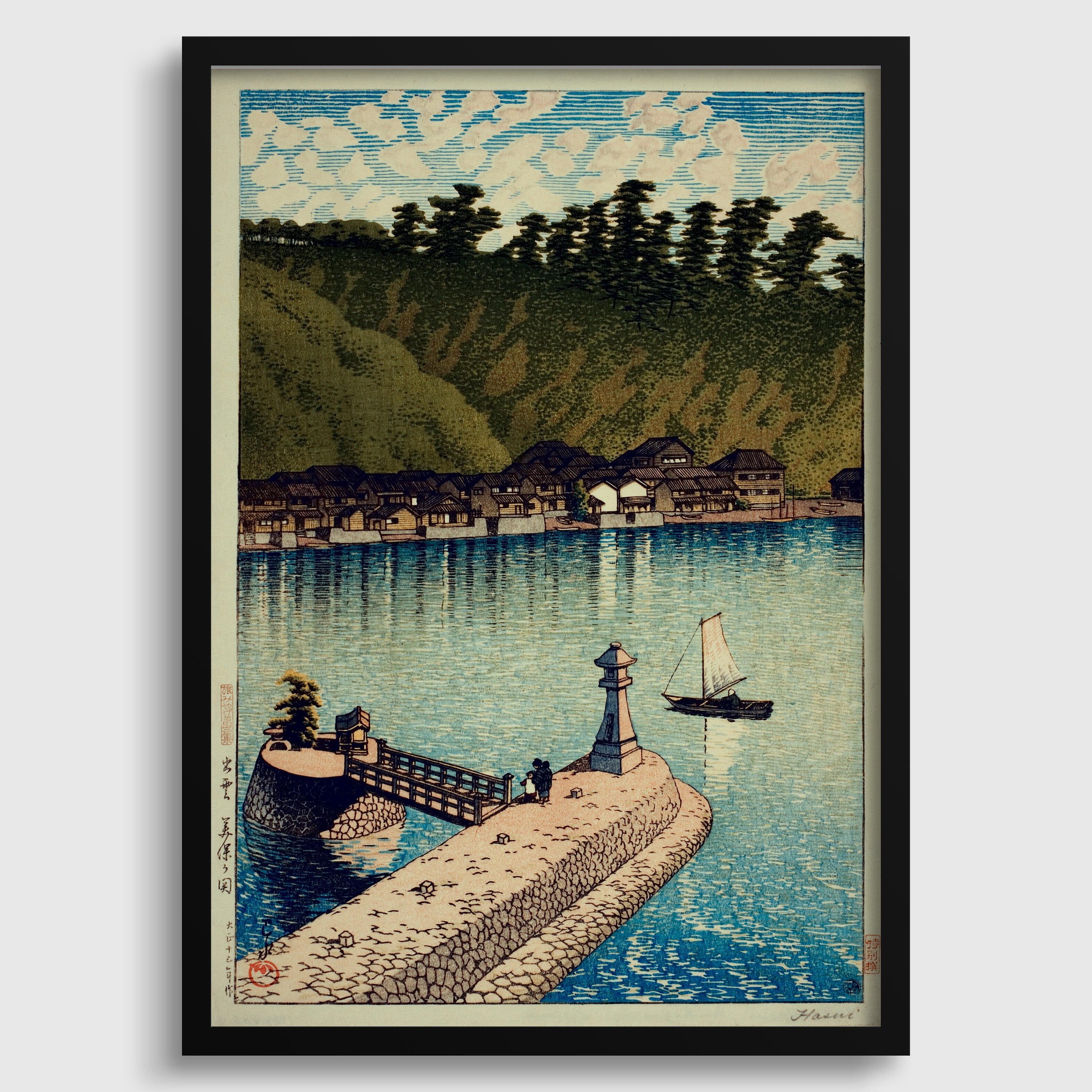 The image is a framed print depicting a serene landscape with a small village situated on the shore of a body of water, surrounded by lush greenery.