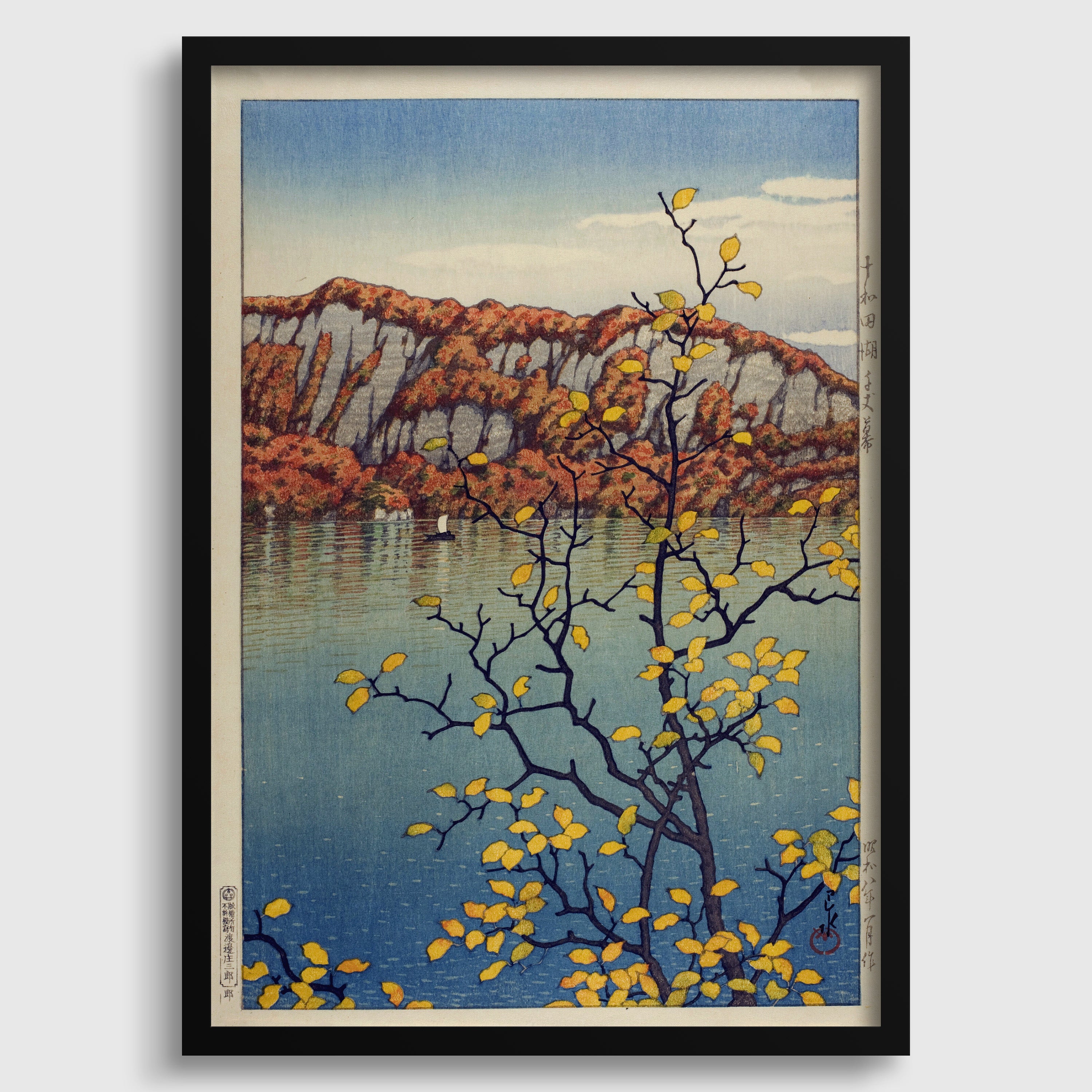 The image is a framed artwork depicting a serene landscape with a mountain in the background, a body of water in the foreground, and a tree with yellow leaves.