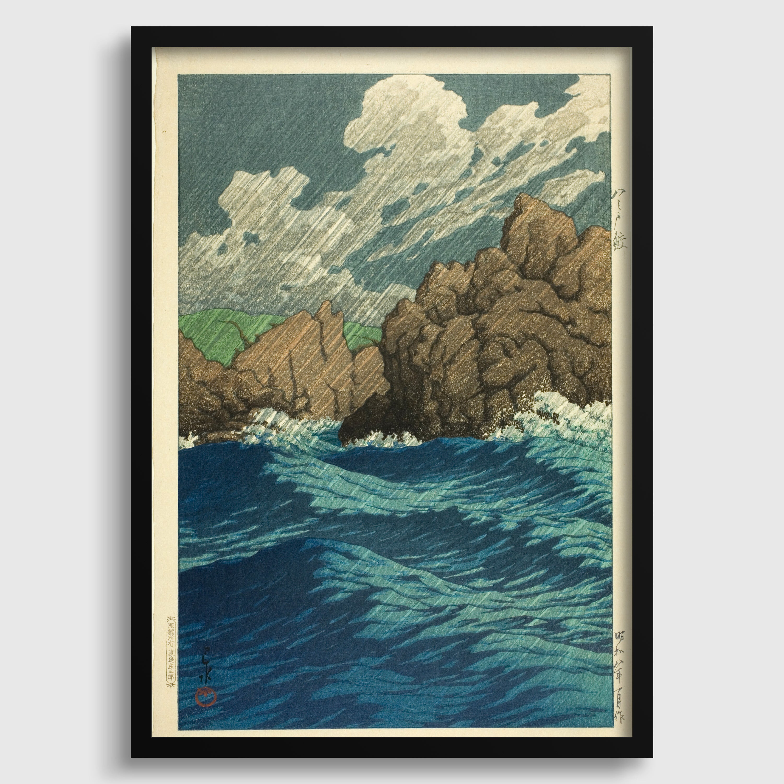 The image is a framed artwork depicting a serene landscape with a rocky coastline, a body of water, and a cloudy sky.
